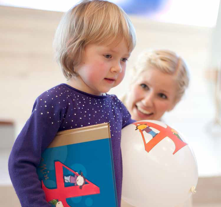 Barn med 4-årsbok og ballong